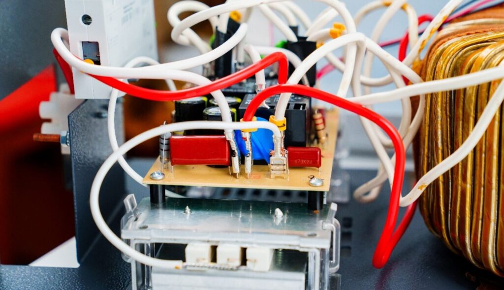 Internal view of an electrical device showing circuit board and wiring (use case for flame-retardant nonwovens around wiring, motors, and capacitors)